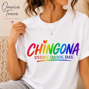 May include: A white short-sleeved t-shirt featuring the text CHINGONA in a rainbow-coloured brushstroke font, with a small heart above the letter I. Below, the text EVERY. DAMN. DAY. is printed in a matching rainbow gradient colour scheme.