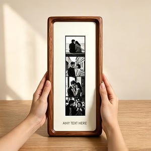 Peut inclure: Un cadre photo rectangulaire en bois avec un passe-partout de couleur claire contenant une bande verticale de quatre photographies en noir et blanc d'un couple. Le texte ANY TEXT HERE est imprimé en noir au bas du passe-partout.