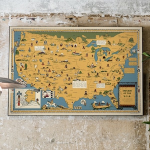 Puede incluir: Un mapa vintage de los Estados Unidos que representa las diferentes tribus nativas americanas que viv&iacute;an en cada regi&oacute;n. El mapa se titula "Indians of the U.S.A." y presenta una ilustraci&oacute;n colorida de una canoa con personas remando.