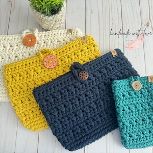 May include: Four crocheted bags in different colors and sizes, with wooden buttons and colorful fabric accents. The bags are arranged on a white wooden surface. The text "handmade with love by Lisa" is visible in the upper right corner of the image.