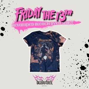 Puede incluir: Una camiseta negra de manga corta con un patrón teñido con lejía que presenta un gráfico de una silueta y el texto Friday the 13th. La camiseta tiene cuello redondo y una estética desgastada creada por el tratamiento con lejía en la tela.