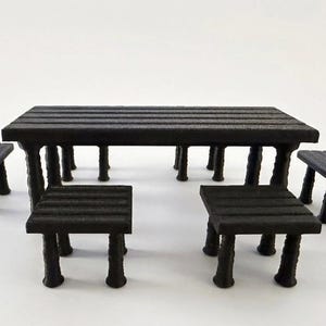 May include: A miniature black dining set consisting of one rectangular table with a slatted top and four matching square stools. Each piece features four textured, tapered legs. The set is constructed from a matte black material with a visible finish.