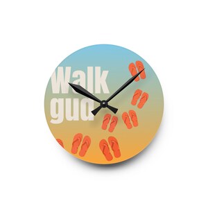 Könnte beinhalten: Eine runde Wanduhr mit einem Farbverlauf von Hellblau zu Orange. Das Zifferblatt zeigt den weißen Schriftzug "Walk gud" und ein Muster aus orangefarbenen Flip-Flops. Sie hat schwarze Zeiger für Stunden, Minuten und Sekunden.