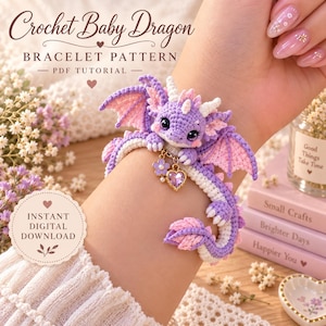 May include: A crochet baby dragon bracelet featuring a purple and white yarn dragon with pink-accented wings, large dark eyes, and a gold-tone charm with a purple heart and flower. Text reads: Crochet Baby Dragon BRACELET PATTERN PDF TUTORIAL.