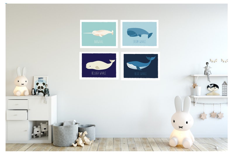 May include: Four framed art prints featuring illustrations of whales: a narwhal, sperm whale, beluga whale, and blue whale. Each print has a different background color and the whale's name below.