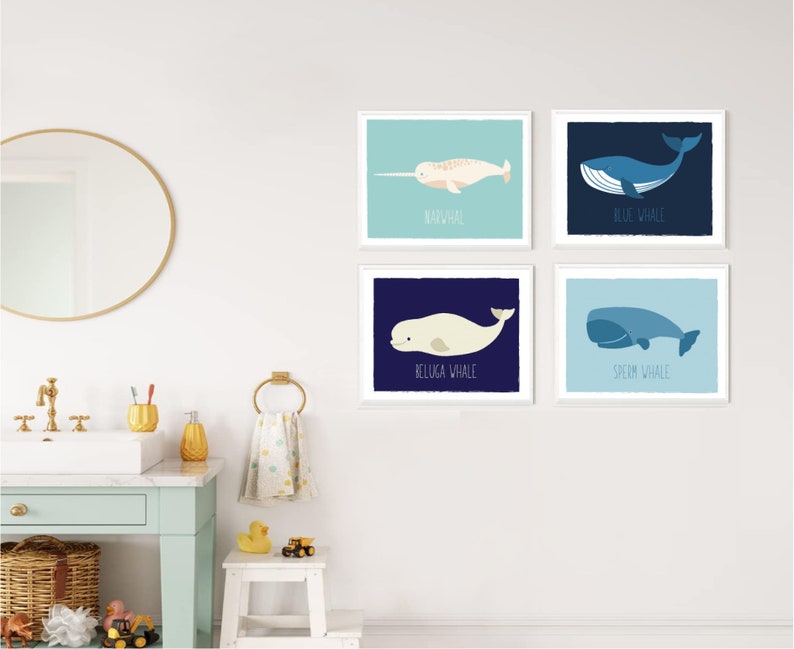 May include: Four framed art prints featuring illustrations of whales. Each print has a different whale species: Narwhal, Blue Whale, Beluga Whale, and Sperm Whale. The prints are in a child's bathroom.