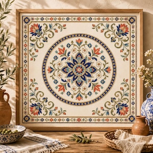 Peut inclure: Une broderie au point de croix carrée encadrée en bois clair, présentant un médaillon circulaire central avec un motif floral symétrique dans des tons de bleu, orange et vert sur un fond en tissu crème, entouré d'une bordure décorative.