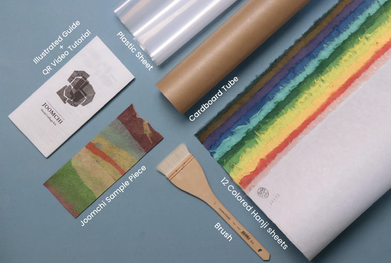 May include: A Joomchi collage kit containing an illustrated guide with QR video tutorial, a plastic sheet, a brown cardboard tube, a Joomchi sample piece, a wooden brush, and 12 colored Hanji sheets arranged in a rainbow gradient pattern.