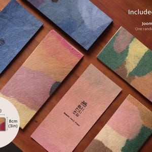 May include: Rectangular Joomchi Hanji paper sheets with textured surfaces in various colors including blue, pink, green, and yellow. Text reads Included in the Kit, Joomchi Hanji Sample, One random piece is included. Dimensions are 7 inches by 3 inches.