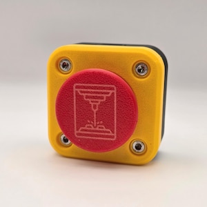 May include: A square yellow push button with a textured red circular center. The red button features a white line-art icon of a 3D printer. The yellow housing is secured by four silver-colored metal screws located at each of the four corners.