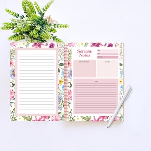May include: Open floral-patterned notebook with the words "Sermon Notes" on the right page. The notebook has lined pages and a spiral binding. A white pen rests on the right side. The floral design includes pink, purple, and blue flowers.