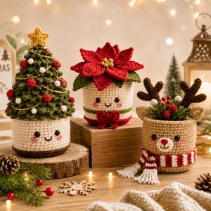 Op de afbeelding: Drie gehaakte amigurumi-figuren: een groene kerstboom met een gele ster, een rode kerststerbloem en een beige rendier met bruine geweien en een rood-wit gestreepte sjaal. Elk figuur heeft een lachend gezicht met roze wangen.