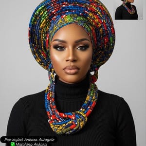 May include: A pre-styled Ankara autogele headwrap featuring a vibrant multi-coloured geometric pattern in red, blue, yellow, and green. The set includes a matching fabric necklace and dangling earrings, all crafted from the same patterned textile.
