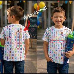 Può includere: Una t-shirt bianca a maniche corte con una stampa alfabetica colorata. Il retro mostra il nome OSKAR cerchiato in rosso, mentre il davanti presenta la parola SCHULKIND cerchiata in rosso. È visibile il testo Personalisierbar! con una freccia.