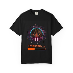 May include: A black t-shirt featuring a graphic of a glowing, circuit-patterned brain in shades of blue, purple, and red. Below the brain, the text "Thinking..." appears in orange, accompanied by a partially filled orange loading progress bar.