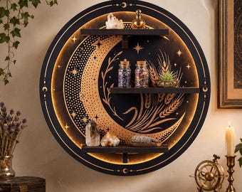 May include: A circular black wall shelf featuring a glowing crescent moon cutout with gold-toned star and wheat engravings. The shelf has three horizontal tiers holding small glass jars, crystals, a succulent, and a bundle of dried herbs.