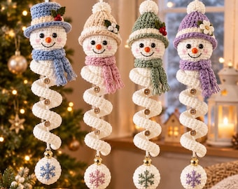 May include: Four hanging crochet snowman ornaments with spiral bodies, each wearing a unique colored hat and scarf. The snowmen feature wooden buttons on their white spiral torsos and a small gold bell attached to a white ball with a snowflake design.