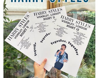 May include: Three white rectangular posters featuring Harry Styles Wembley London setlists for nights 5, 11, and 12. The posters display song titles in black text and one poster includes a colorful illustration of a person singing into a microphone.