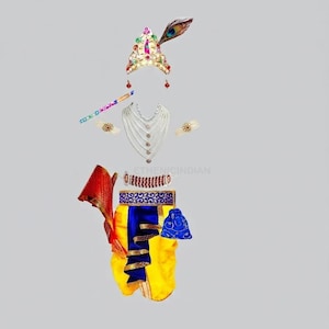 May include: A costume set featuring a gold crown with a peacock feather, a multi-strand pearl necklace, a flute, armbands, a red and gold sash, a yellow and blue dhoti, and a small blue pouch. The set includes a red and white beaded waist belt.