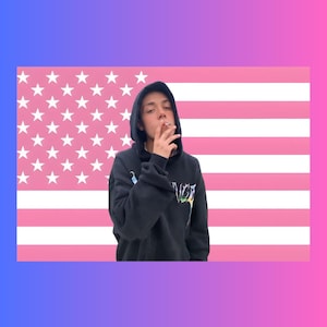 May include: A black hooded sweatshirt featuring a graphic design on the chest, worn by a person holding a cigarette. The background is a stylised American flag with horizontal stripes and stars in shades of pink and white, framed by a blue-to-pink gradient.