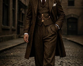 Puede incluir: Un traje de tres piezas de tweed marrón que incluye un abrigo largo, un chaleco con cadena de reloj de bolsillo dorada, una camisa blanca de cuello, una corbata oscura y una gorra plana. El texto CUSTOMTAILRING aparece en las esquinas.