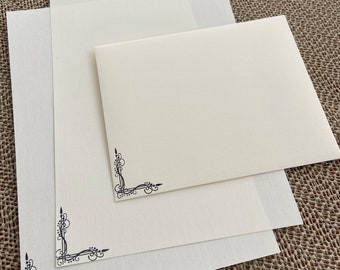 May include: Three white sheets of paper with decorative black corner designs. The sheets are stacked on top of each other.