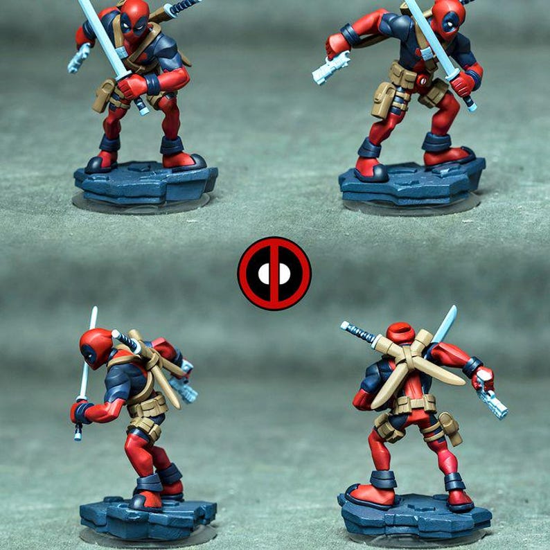 May include: Four views of a painted Deadpool miniature figure in a red and black suit with tan utility belts. The character holds light blue swords and pistols, standing on a dark blue rocky base. A circular red and black Deadpool logo is centered.