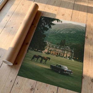 May include: A rectangular art print featuring a landscape scene with a large stone manor house, two brown horses grazing on a green lawn, and a black vintage car parked on the grass, accompanied by a cylindrical brown cardboard shipping tube.