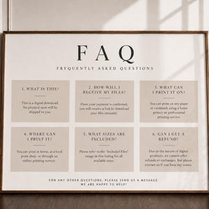 May include: A rectangular sign with a white background and a thin brown frame. The text FAQ FREQUENTLY ASKED QUESTIONS appears at the top. Below are six beige boxes containing numbered questions and answers regarding digital download policies.