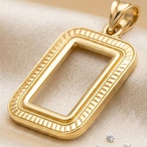 May include: A rectangular gold pendant featuring a hollow center and a textured border with repeating vertical lines. The pendant includes a polished gold bail at the top and is surrounded by four small, loose, clear, round-cut gemstones.