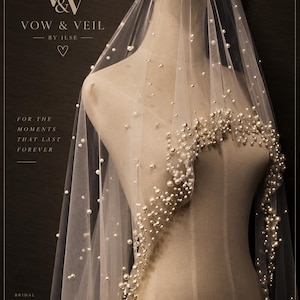 Op de afbeelding: Een doorschijnende witte bruidssluier gedrapeerd over een paspop, versierd met verspreide witte parels die zich dicht langs de rand clusteren. De tekst VOW & VEIL BY ILSE, FOR THE MOMENTS THAT LAST FOREVER en BRIDAL VEILS FOR A MORE BEAUTIFUL TOMORROW is zichtbaar.