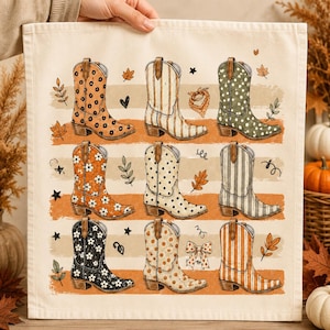 Puede incluir: Un paño de tela color crema con una cuadrícula de nueve botas vaqueras con varios patrones, incluyendo diseños florales, de lunares y de rayas. Las botas están dispuestas en tres filas sobre trazos de pincel naranjas horizontales con hojas y estrellas.