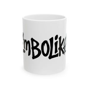 Puede incluir: Una taza de cerámica blanca con el texto negro "I'mBOLIK" impreso en una fuente negrita y estilizada de trazo de pincel en el centro. La taza tiene una forma cilíndrica con un acabado liso y una abertura ancha en la parte superior.