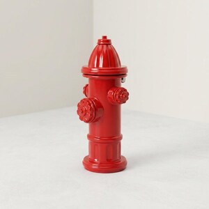 May include: A bright red fire hydrant featuring a cylindrical body, a domed top, and three protruding circular valve caps. The object has a smooth, glossy finish and a structured base, standing upright with a uniform, vibrant red color throughout.