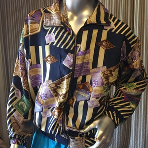 May include: A black and gold striped jacket with a zipper closure. The jacket is covered in a variety of colorful patches and labels. The jacket is made of a silky material.