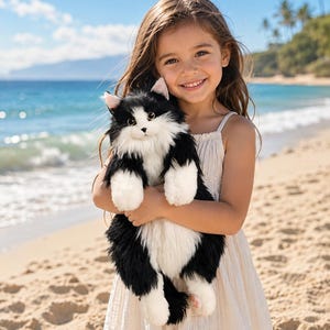 Peut inclure: Une peluche en forme de chat avec une fourrure longue et douce noire et blanche, des oreilles pointues aux détails roses, de grands yeux sombres et un museau blanc. Le jouet présente un ventre et un poitrail blancs et duveteux.