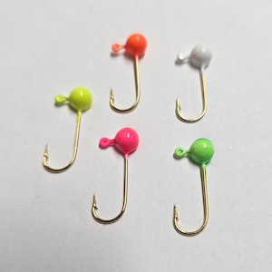 Könnte beinhalten: Eine Sammlung von fünf Angelhaken mit goldfarbenen Haken und runden, lackierten Köpfen in Neonorange, Weiß, Neongelb, Pink und Limettengrün. Jeder Haken verfügt über eine kleine Öse am Kopf zur Befestigung der Angelschnur.