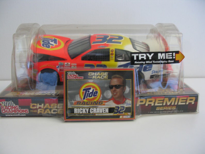 Może przedstawiać: Model samochodu wyścigowego Tide Racing #32 Ricky'ego Cravena w skali 1/24. Samoch&oacute;d znajduje się w przezroczystej plastikowej gablocie z obrotową podstawą tunelu aerodynamicznego. Pudełko zawiera r&oacute;wnież kartę ze zdjęciem Cravena i logo Tide.