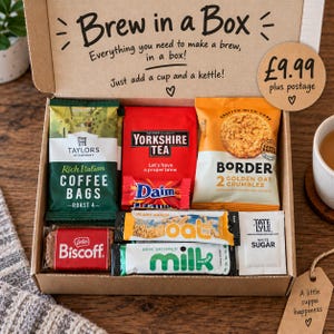 May include: A cardboard gift box labelled Brew in a Box containing Taylors of Harrogate coffee bags, Yorkshire Tea, Border Golden Oat Crumbles, a Daim bar, a Lotus Biscoff biscuit, oat milk, and Tate and Lyle white sugar packets for making tea or coffee.