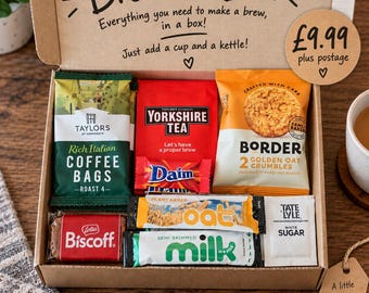 May include: A cardboard gift box labelled Brew in a Box containing Taylors of Harrogate coffee bags, Yorkshire Tea, Border Golden Oat Crumbles, a Daim bar, a Lotus Biscoff biscuit, oat milk, and Tate and Lyle white sugar packets for making tea or coffee.