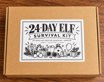 May include: A rectangular brown cardboard box featuring a white rectangular label with black text and illustrations. The label reads 24-DAY ELF SURVIVAL KIT 24 DAYS OF FESTIVE MISCHIEF, SORTED. PROPS ACTIVITIES IDEAS with drawings of gifts, sunglasses, and a North Pole sign.