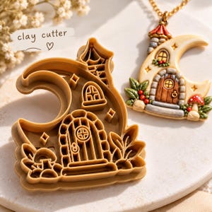 May include: A tan plastic clay cutter shaped like a crescent moon house with a door, window, and mushroom details. Beside it sits a finished pendant featuring a detailed moon house with a brown door, red roof, and green foliage accents.