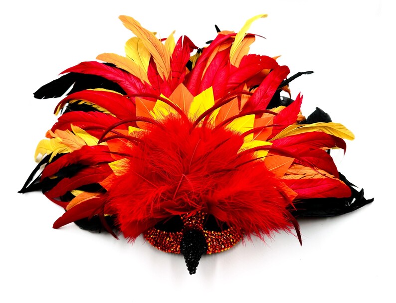 May include: A vibrant, feathered mask in shades of red, orange, yellow, and black. The mask features a beaded base and a central cluster of red feathers, creating a dramatic and eye-catching design. Ideal for costume parties or theatrical performances.