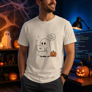 Peut inclure: Un t-shirt couleur crème avec un motif représentant un fantôme utilisant un ordinateur portable avec le texte "BOO... BUT MAKE IT SPOOKY" et une petite citrouille orange à côté. Le fantôme a deux yeux noirs et tient un ordinateur blanc "AI".