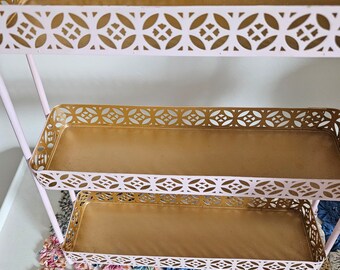 MCM pink and gold three tiered metal shelf.