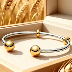 Puede incluir: Una pulsera de cadena de serpiente en tono plateado con un diseño flexible y enrollado. La pulsera está decorada con cuatro cuentas esféricas pulidas en tono dorado, con dos cuentas más grandes en los extremos abiertos y dos más pequeñas.