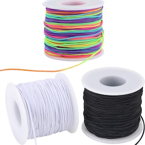 May include: Three spools of elastic cord. One spool features a multi-colored cord with alternating stripes of neon pink, bright green, purple, and orange. The other two spools contain solid white and solid black elastic cord, respectively.