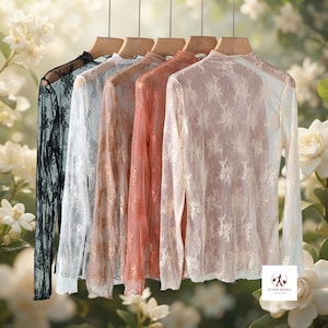 May include: Five long-sleeved mock neck shirts made of sheer lace fabric, hanging on wooden hangers. The shirts are displayed in a gradient of colours including black, white, light blue, peach, and beige, all featuring a floral lace pattern.