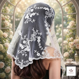 May include: A white lace head covering featuring intricate floral embroidery patterns throughout the sheer fabric. The triangular-shaped veil has a scalloped edge and delicate stitched flower motifs that drape over the hair and shoulders.
