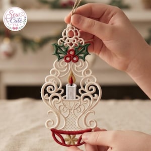 Può includere: Un ornamento in pizzo color crema raffigurante una candela ricamata con una fiamma dorata e rossa, circondata da intricati motivi a volute e sormontata da foglie di agrifoglio verdi e bacche rosse. La base rossa presenta un dettaglio floreale.